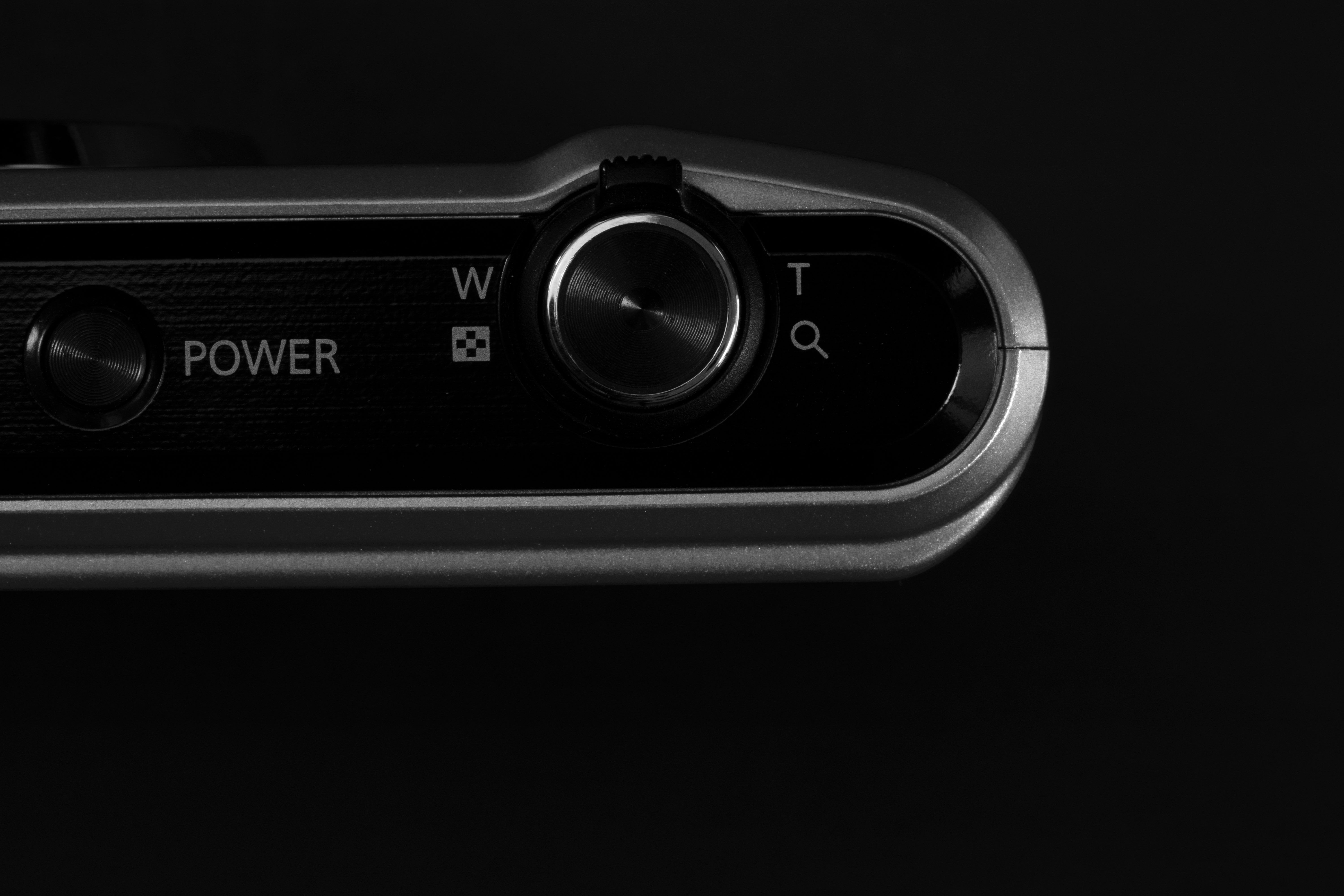 Detailed view of a modern camera's control panel with power and zoom buttons.