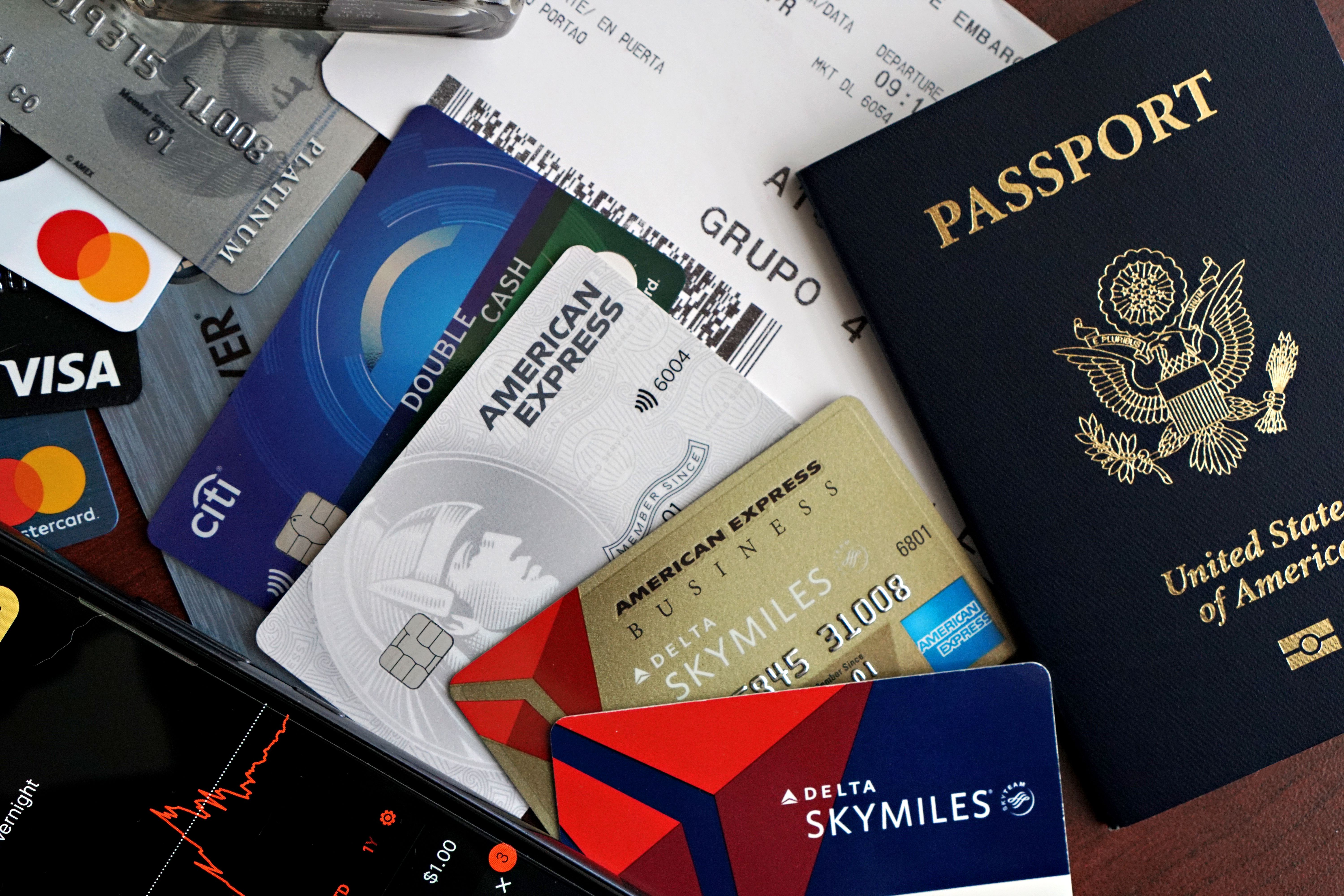 A collection of travel essentials including a passport, credit cards, and a boarding pass. Ideal for travel and finance
