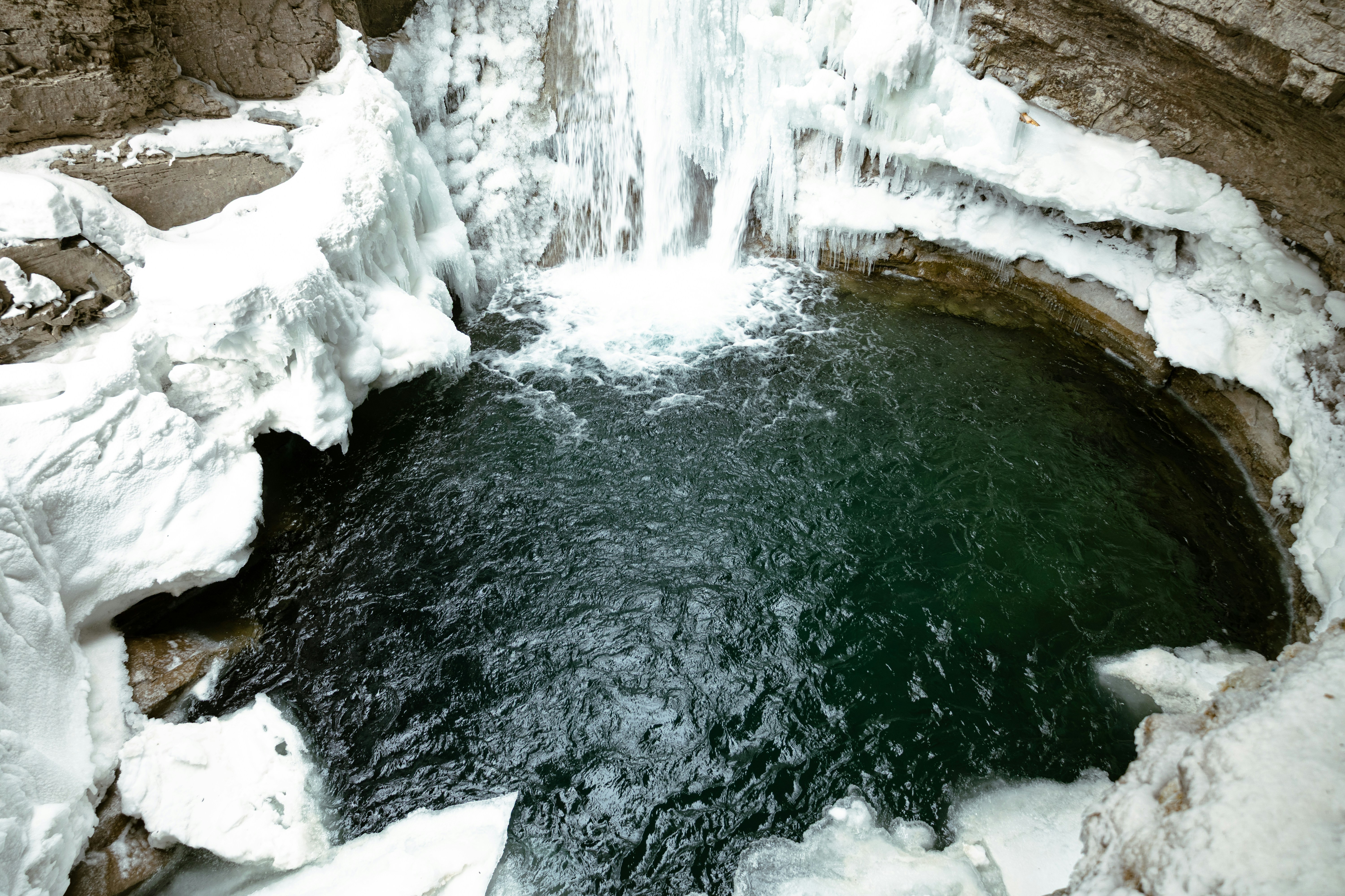 Frozen waterfall cascading into a dark pool