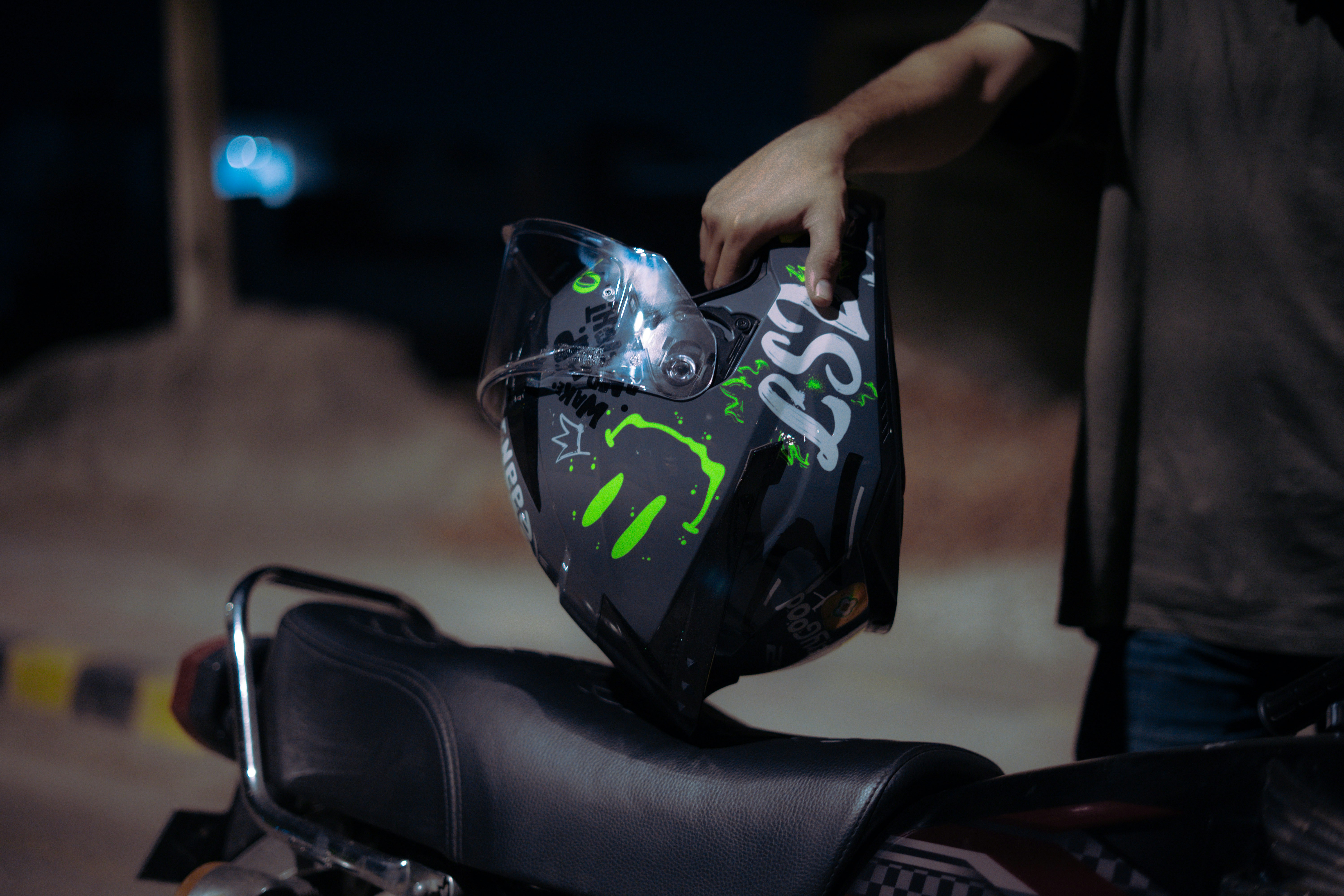 Person holding a motorcycle helmet over a bike seat