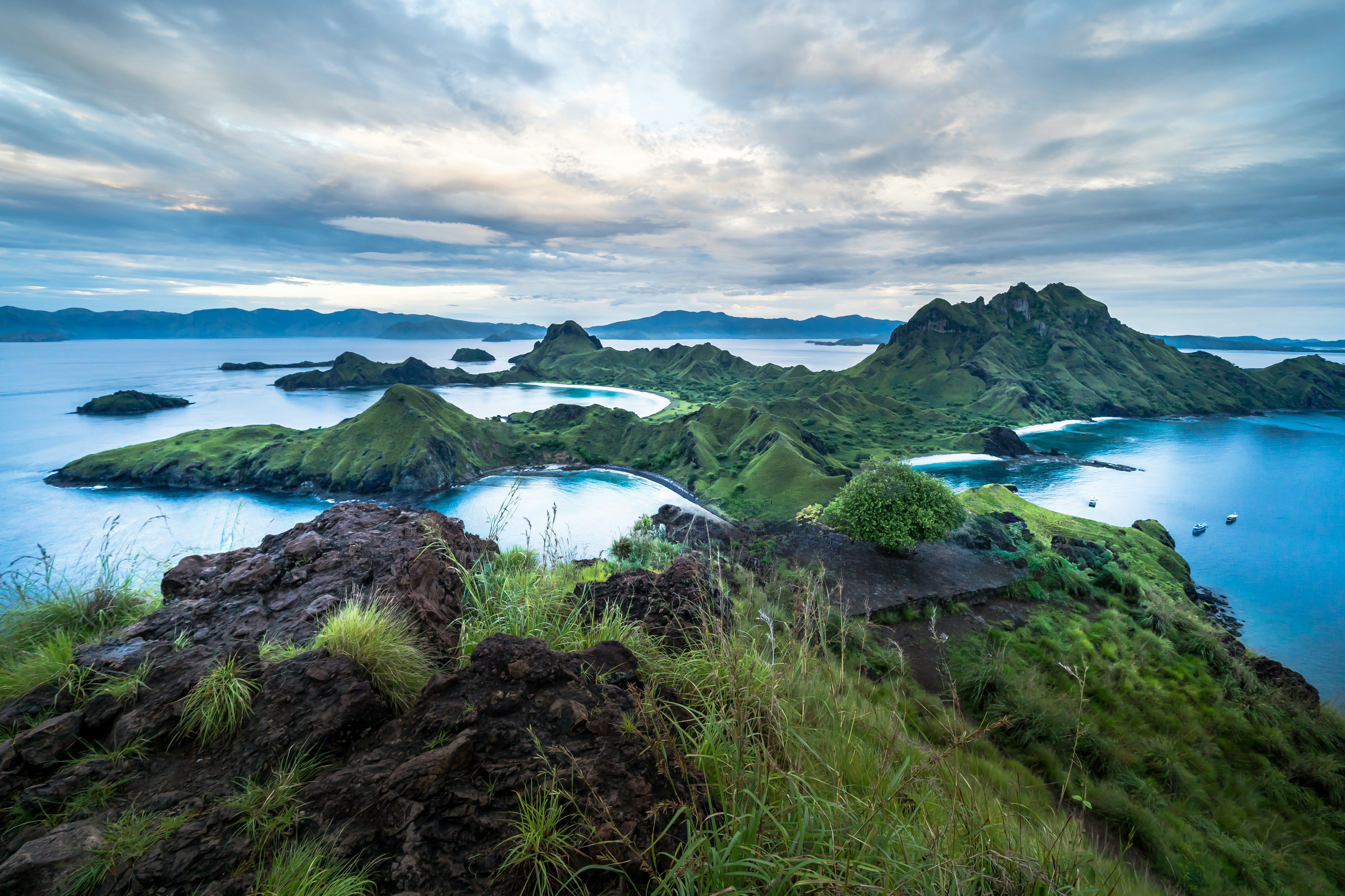 Green islands with blue water under cloudy sky