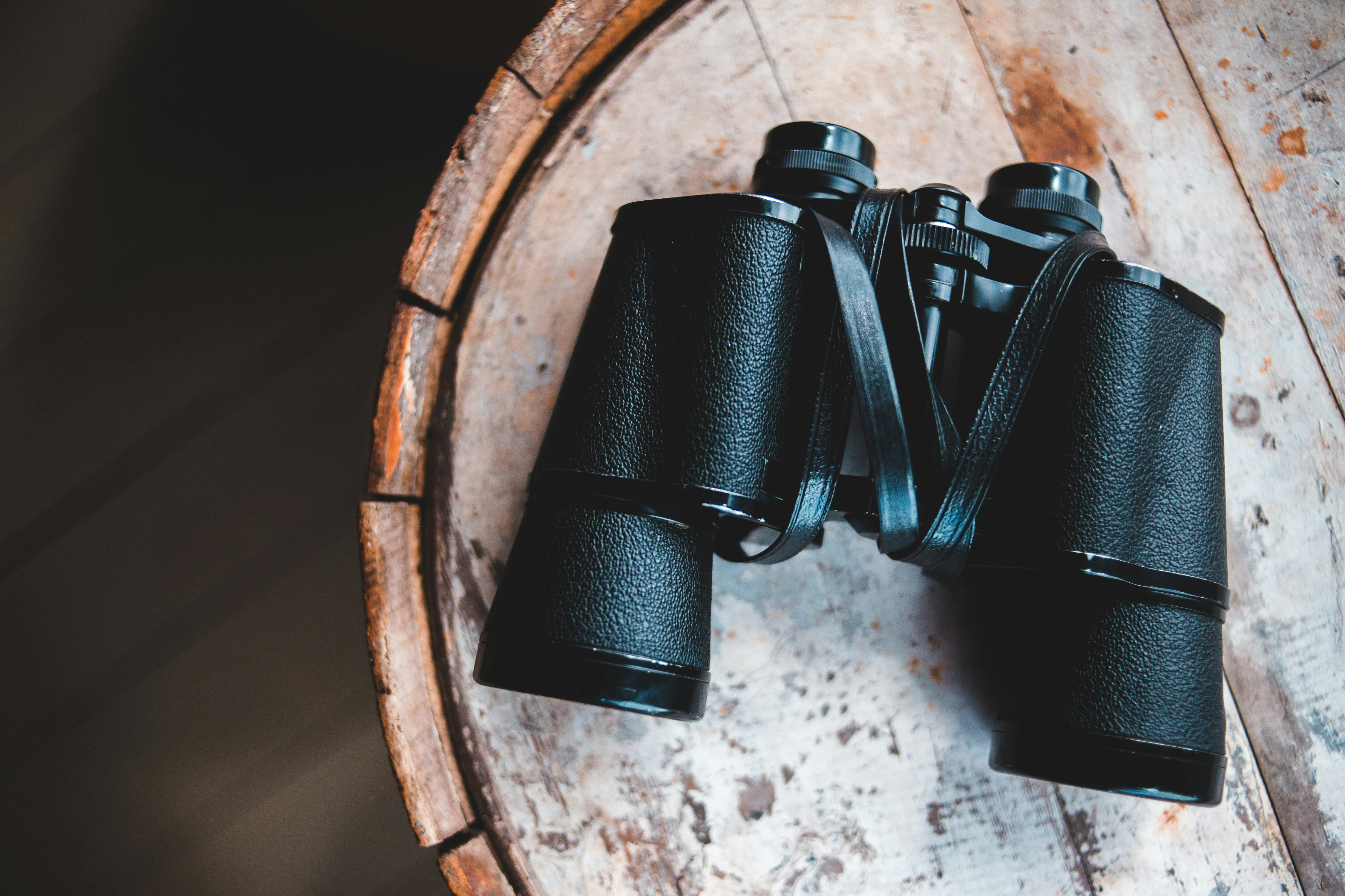 black binoculars on brown wooden table