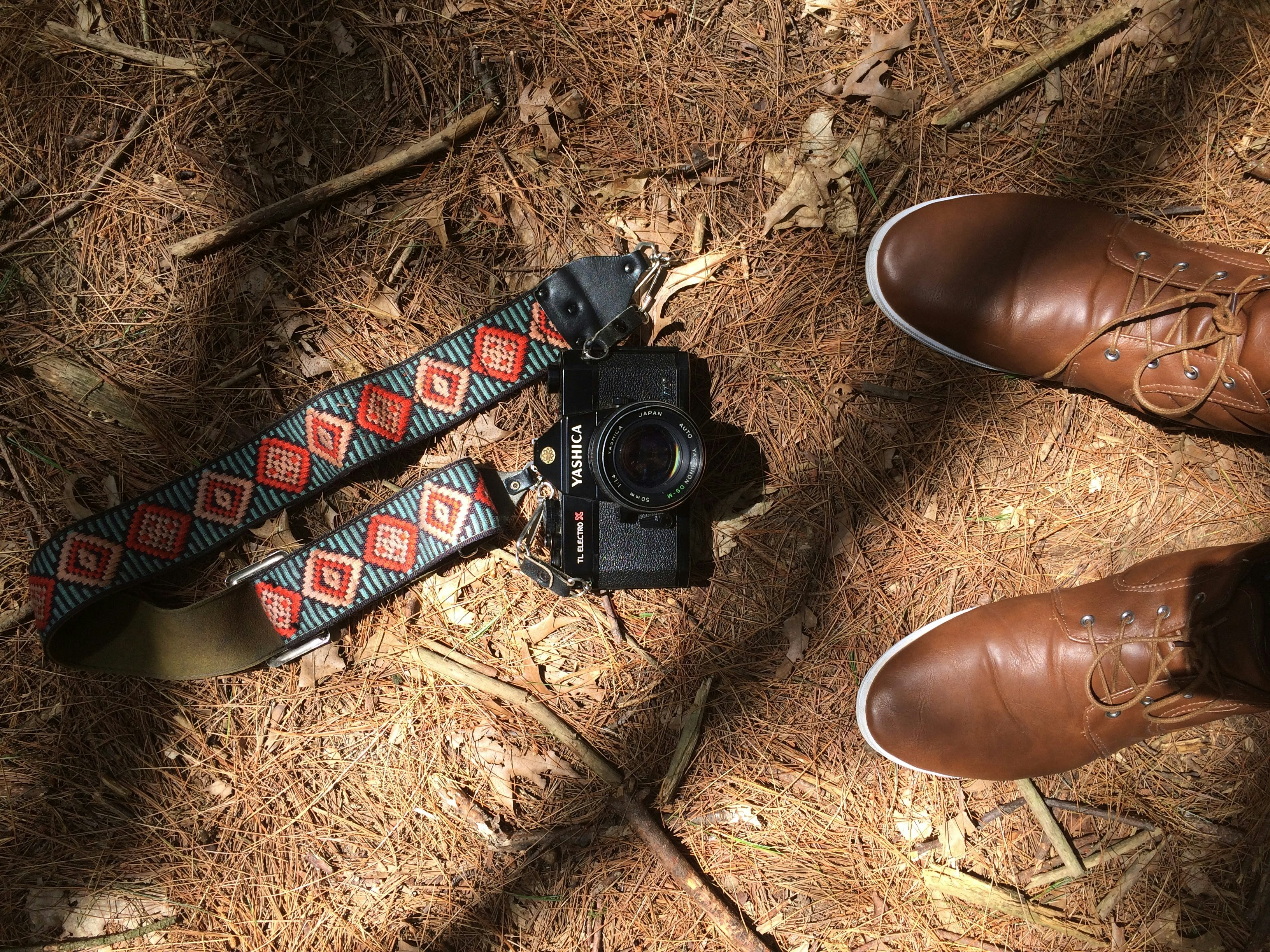 black DSLR camera on brown sand