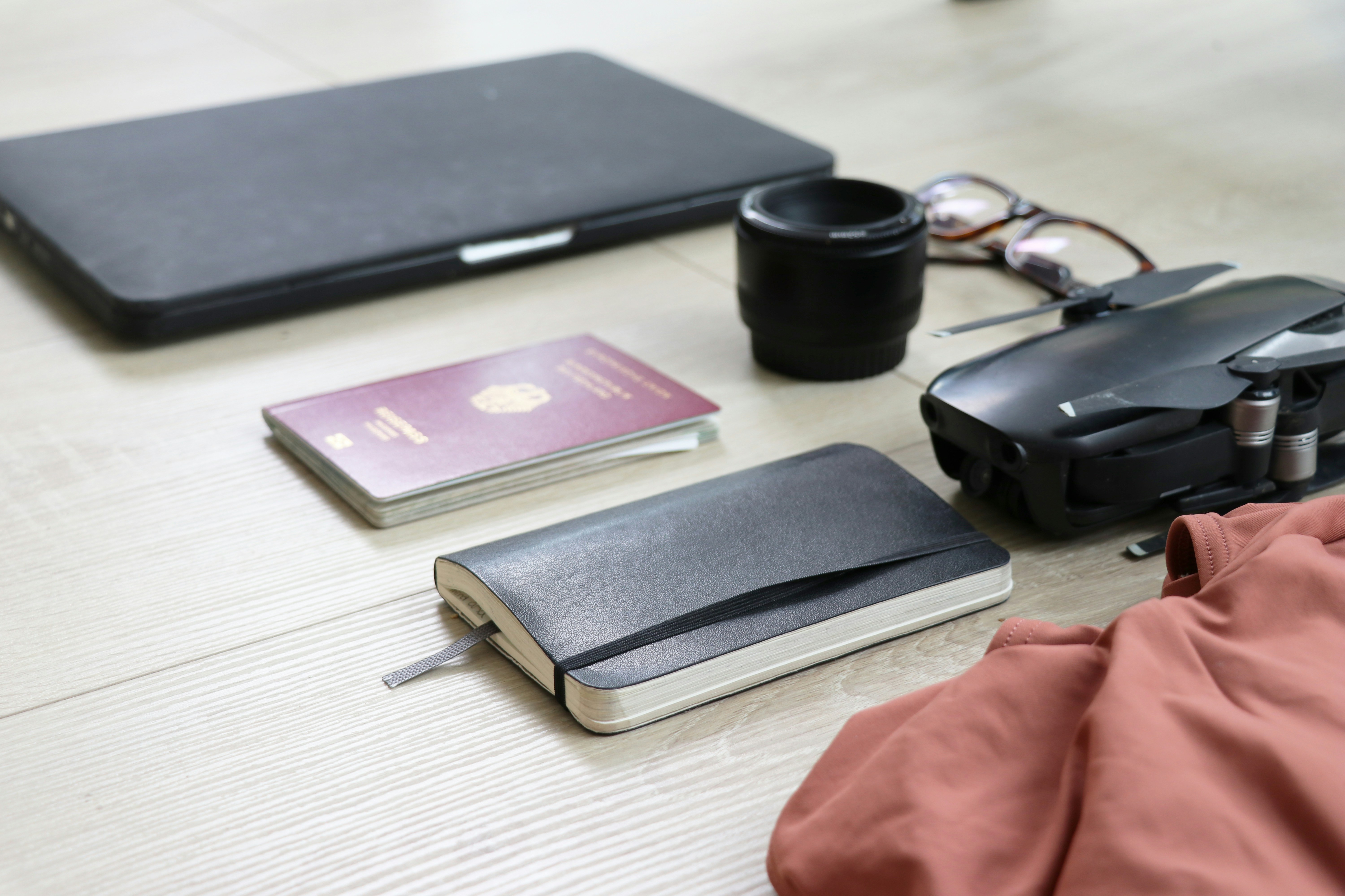 books, camera lens, and drone on wooden surface